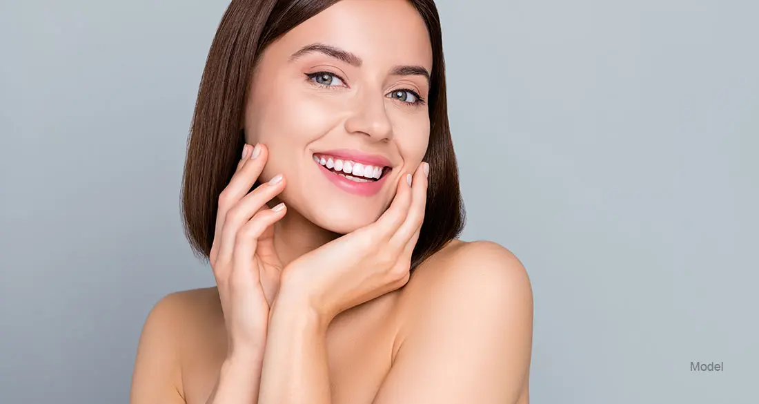 Woman smiling and touching her face